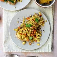 Curried tofu scramble on a piece of toast on a plate