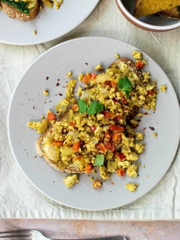 Curried tofu scramble on a piece of toast on a plate