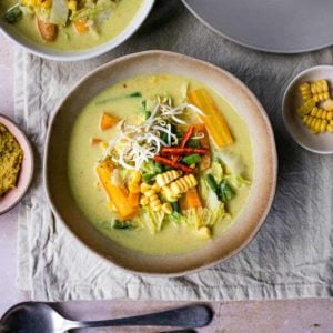 Square image of sayur lodeh in a bowl with more bowls around it