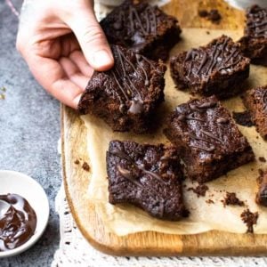 Vegan Christmas brownies on a board with a hand holding one