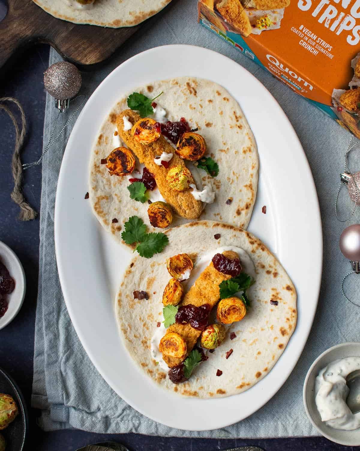 Quorn Christmas tacos (x 2) on a white plate with a Quorn box in the corner