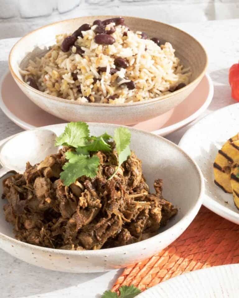 Jerk jackfruit in a bowl with rice and peas in a separate bowl behind it.
