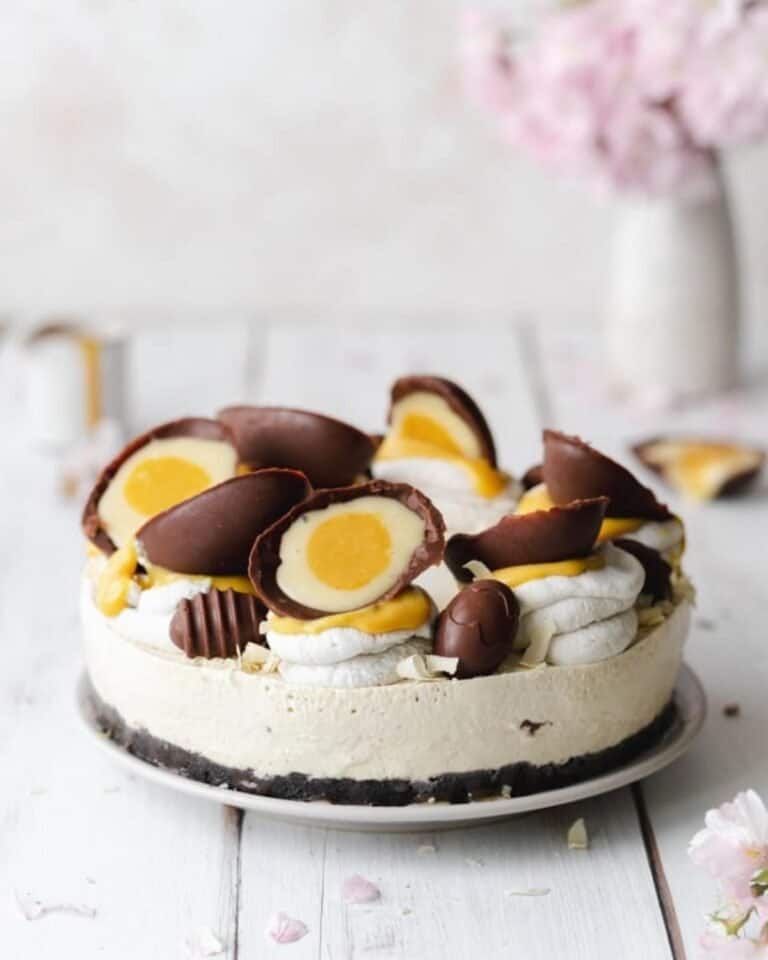 Vegan creme egg cheese cake topped with creme egg replicas that are cut in half.