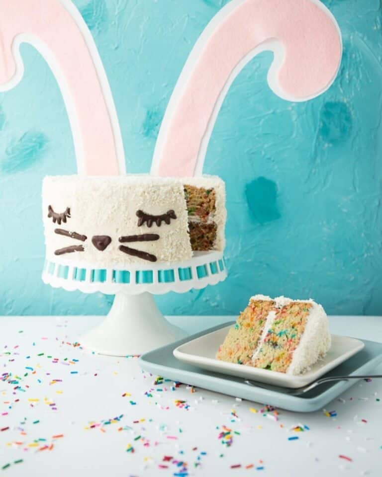 Vegan funfetti bunny cake with large ears, and a slice on a plate.
