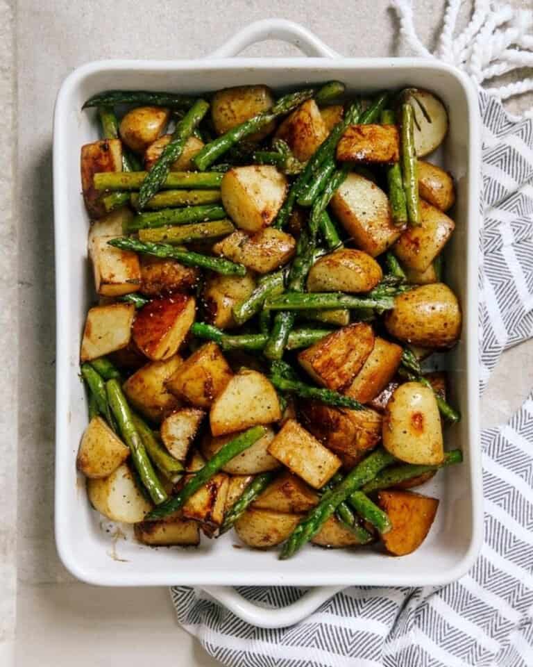 Roasted potatoes in a tray with green beans.