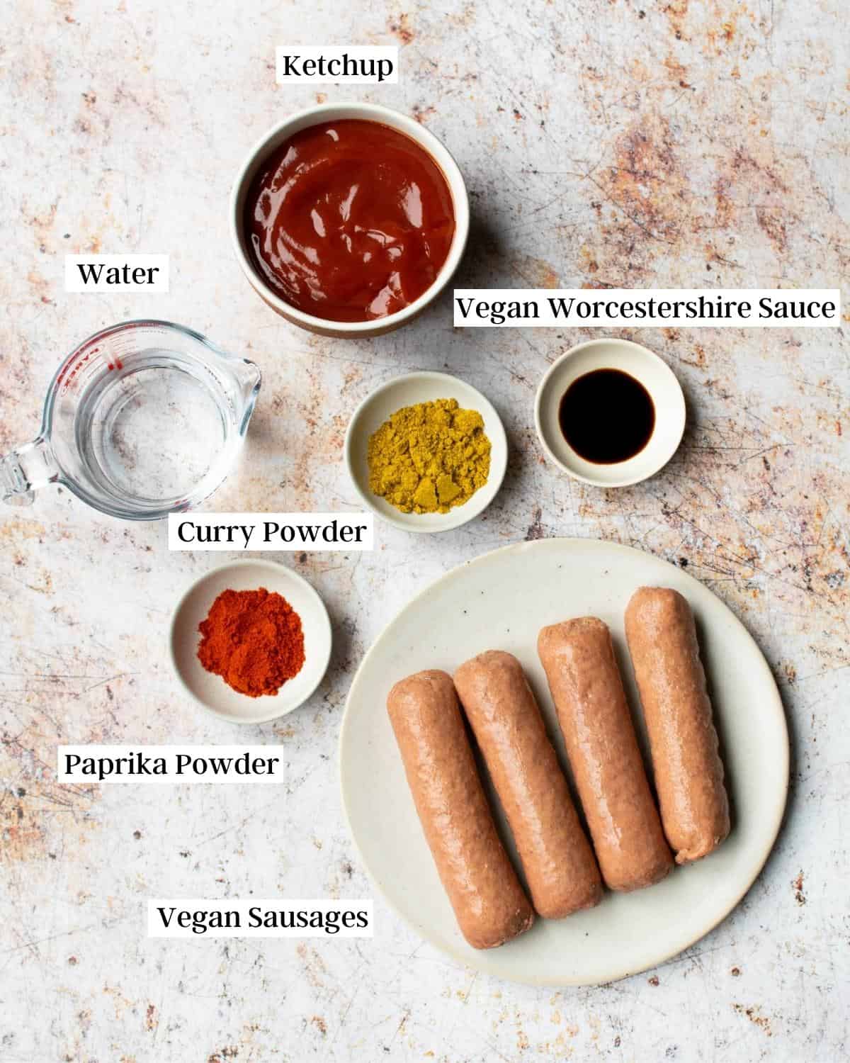 Vegan currywurst ingredients laid out on plates and bowls.