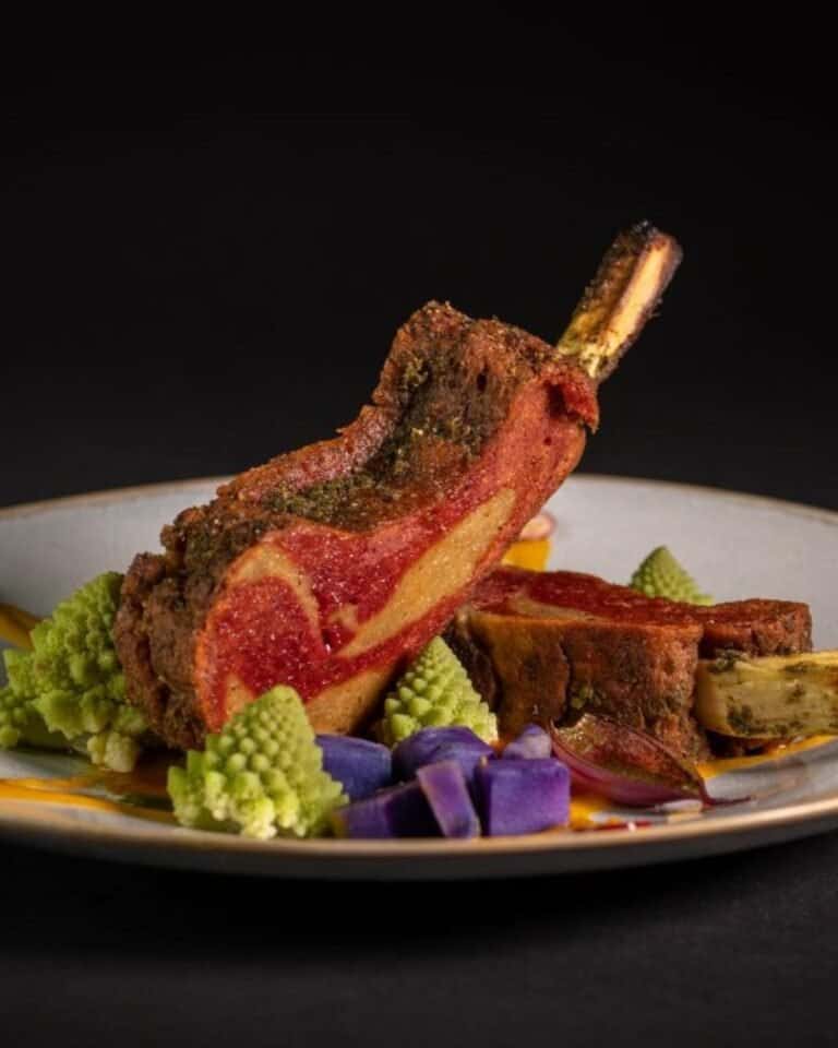 Vegan rack of lamb on a plate with vegetables.