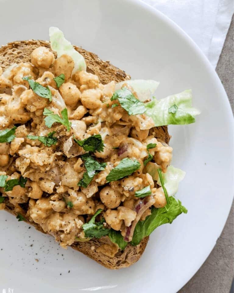 Coronation chickpeas with salad on a piece of toast.