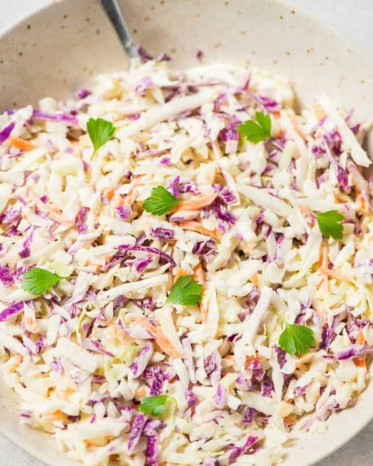 Vegan coleslaw in a bowl with a spoon.