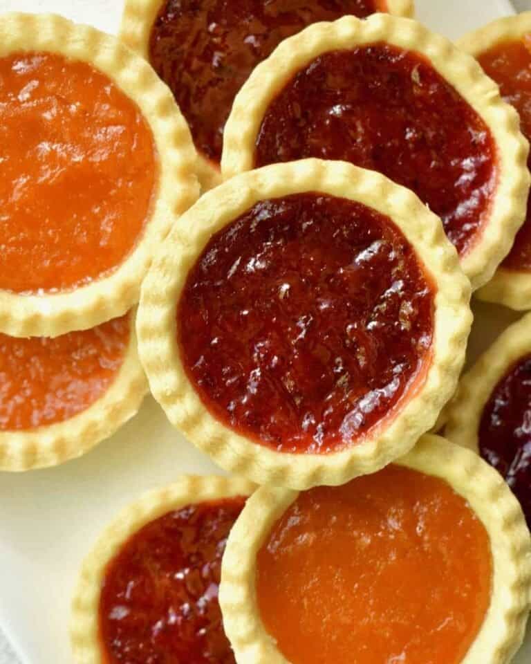 Vegan jam tarts with orange and red jam.