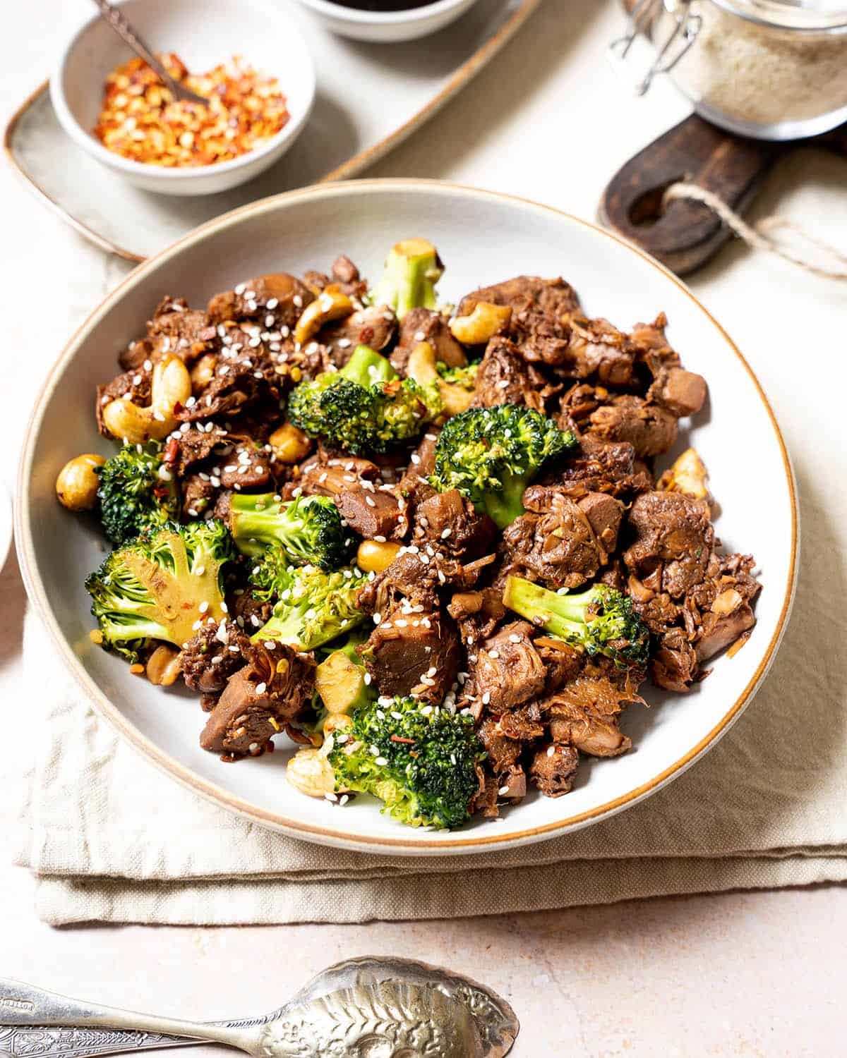 Vegan beef and broccoli topped with sesame seeds in a bowl.