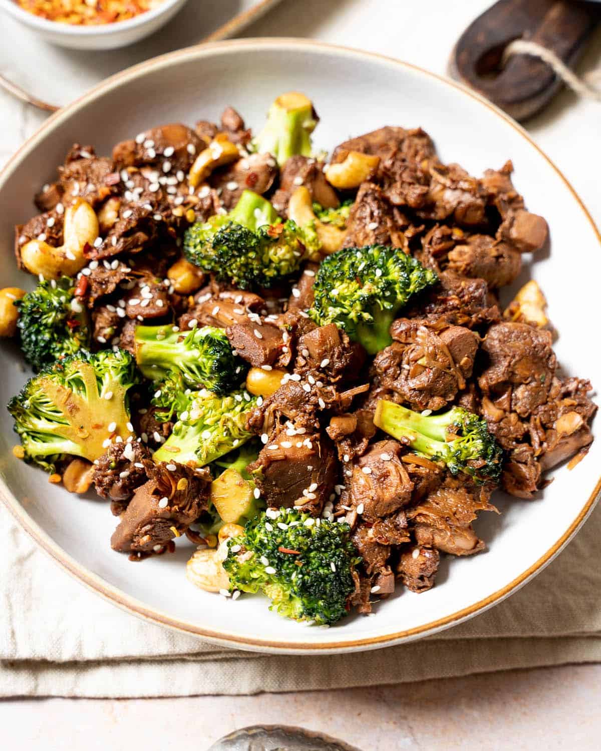 Chinese jackfruit with broccoli in a bowl with chilli flakes in the background.