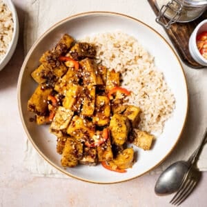 Sticky tofu with brown rice and fresh chilli in a bowl.