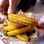 Hands holding up an air fryer corn rib, sweetcorn side out.