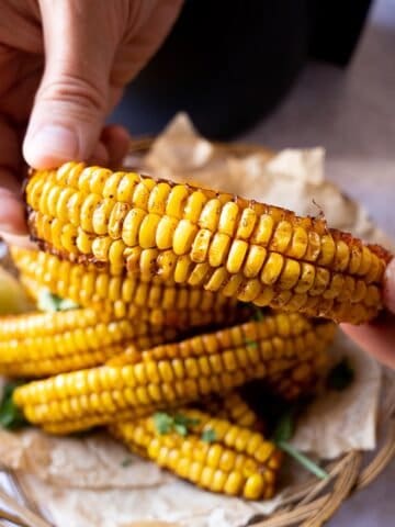 Hands holding up an air fryer corn rib, sweetcorn side out.
