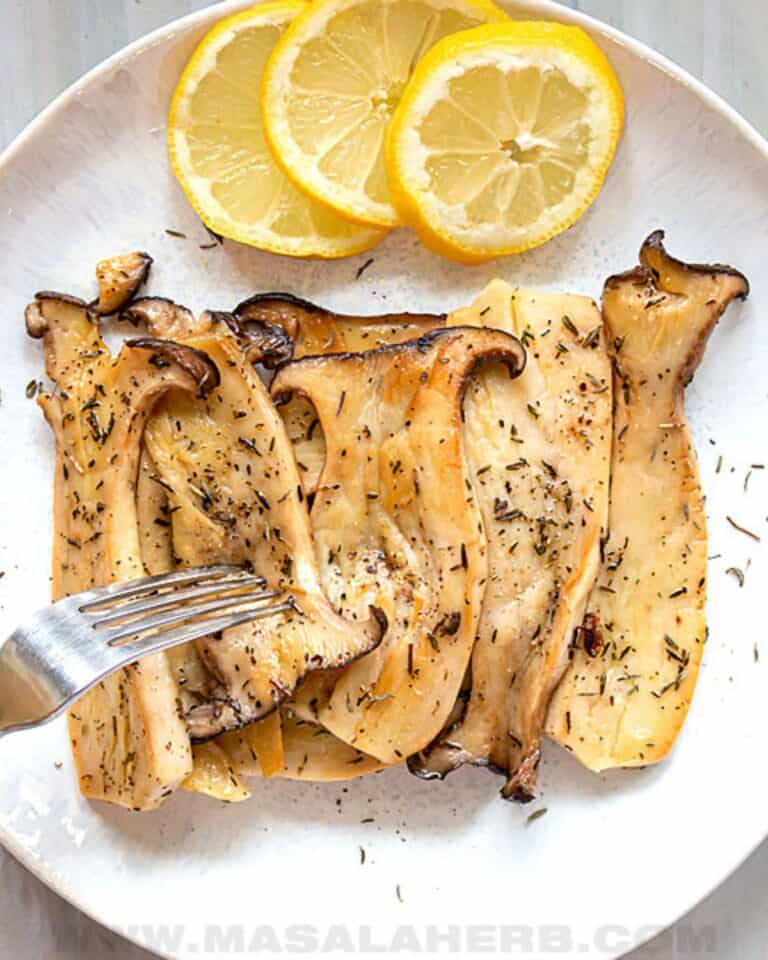 King oyster mushrooms with lemon and herbs and a fork.