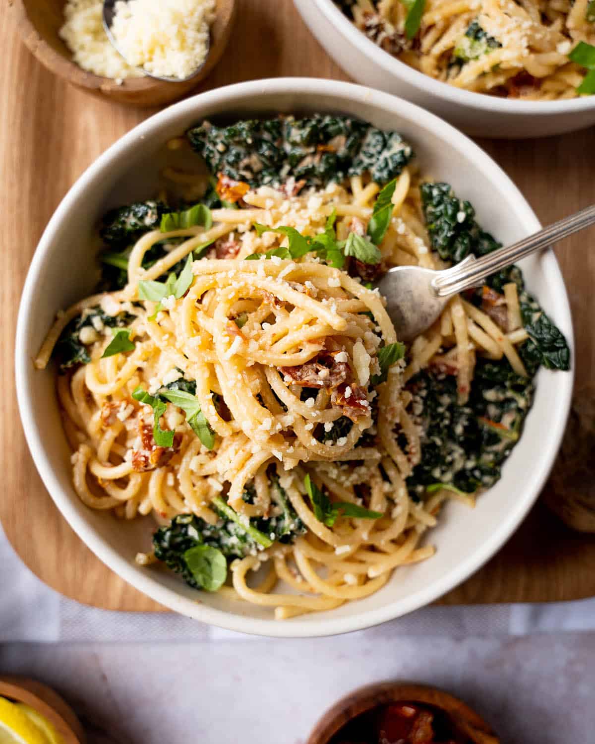 Spaghetti with a fork in the bowl and shredded fresh basil.