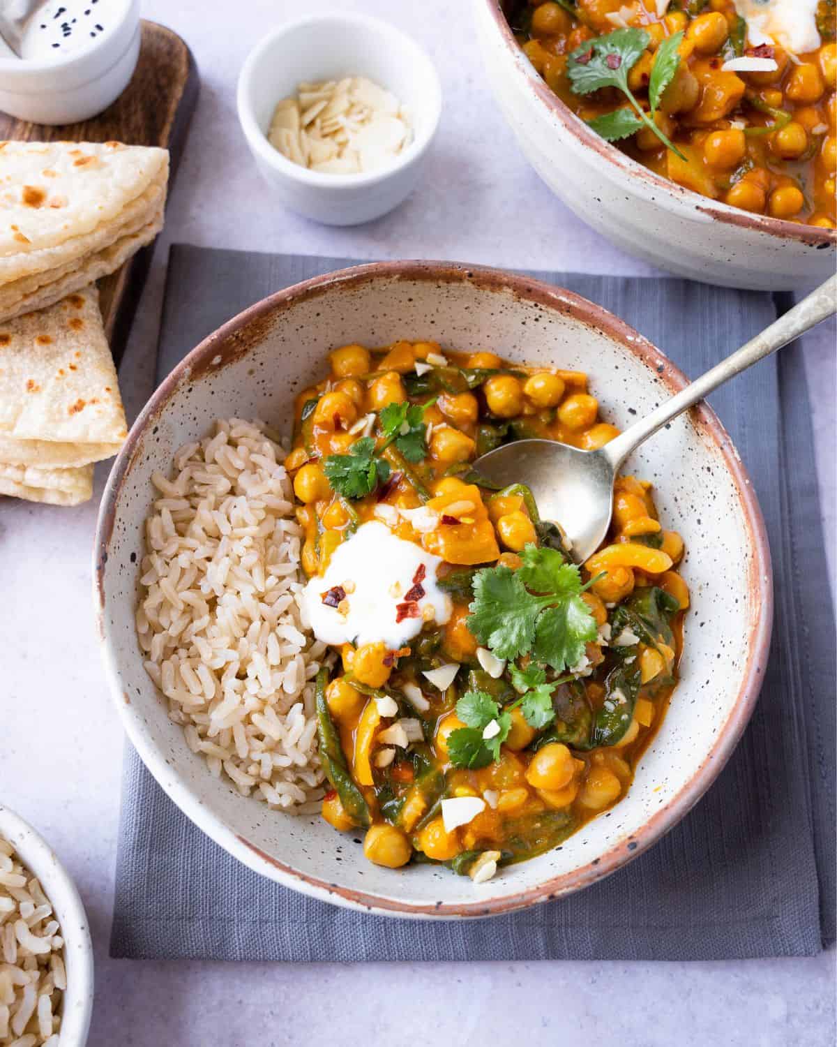 Chickpea and spinach curry with rice and a spoon.