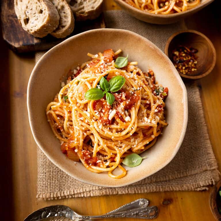 Parmesan topped spaghetti arrabiata with fresh basil and bread.