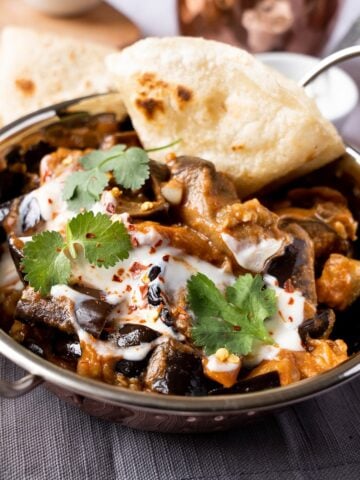 Aubergine curry served with fresh coriander and roti.