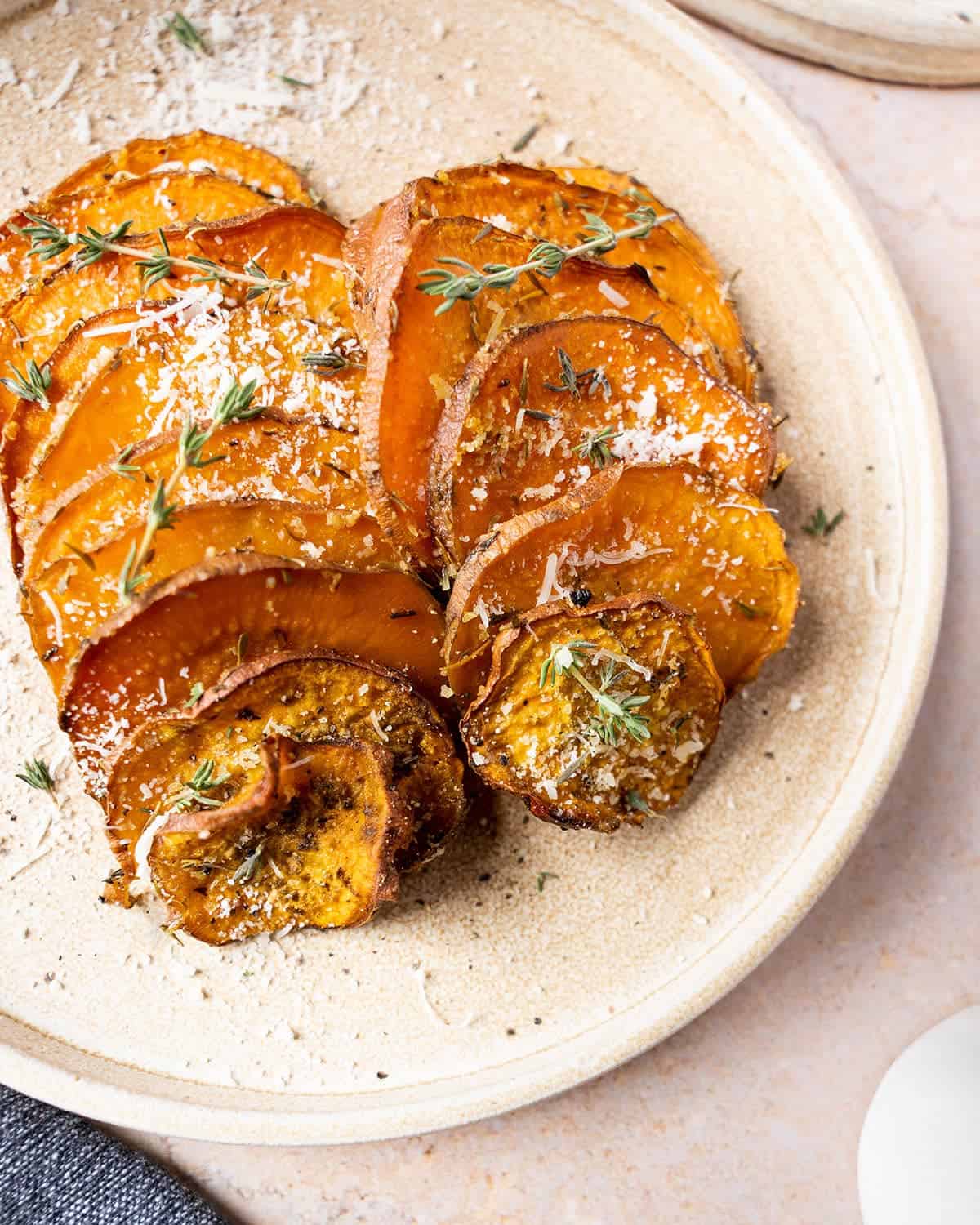Sweet potato rounds on a plate with fresh thyme.