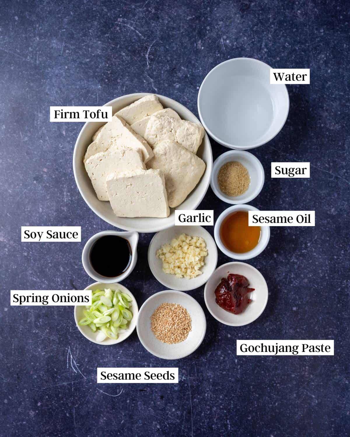 Ingredients for braised tofu on a dark surface.