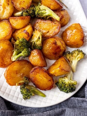 Roasted potatoes and broccoli on a serving plate.
