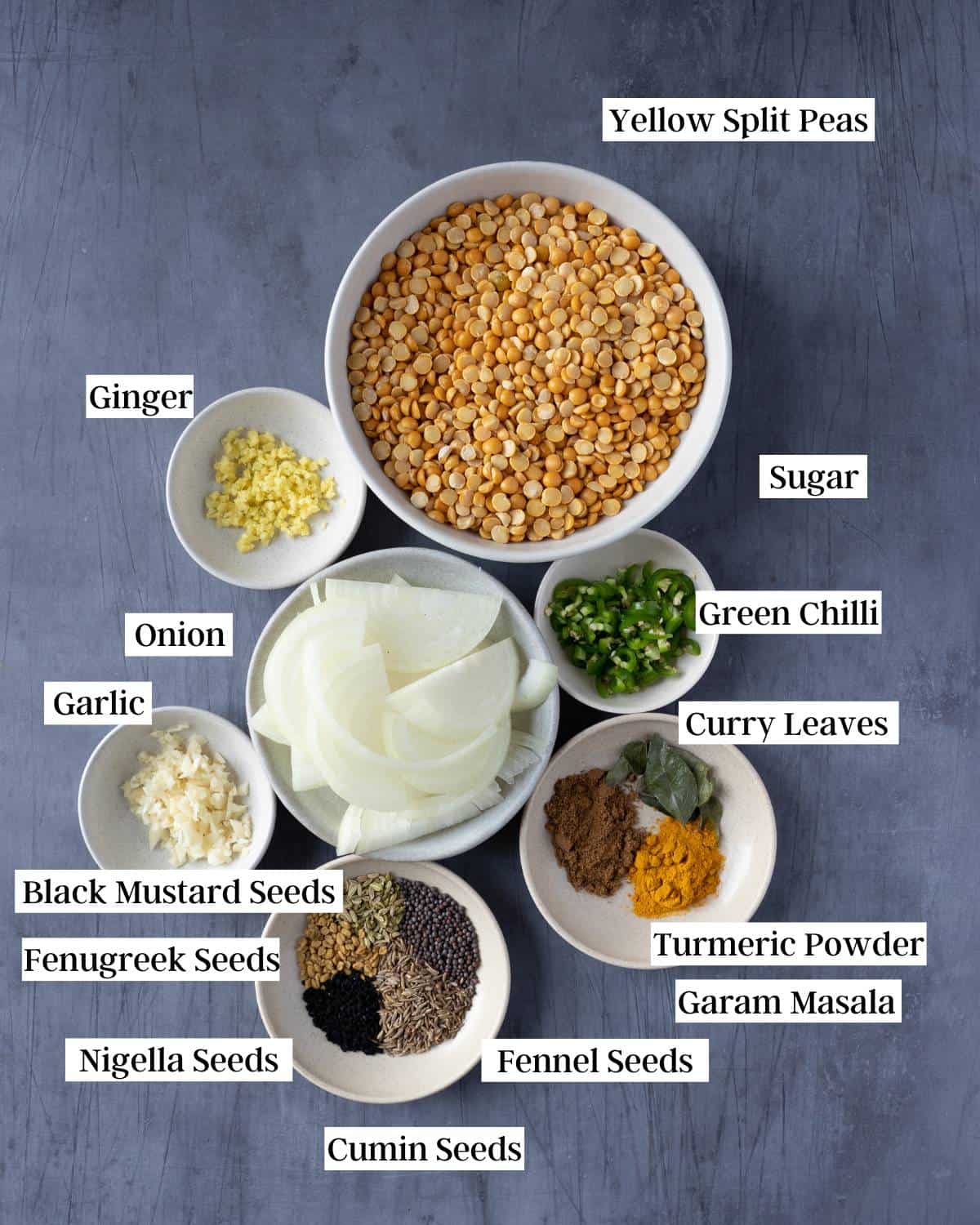 Ingredients for matar dal on a darl surface.