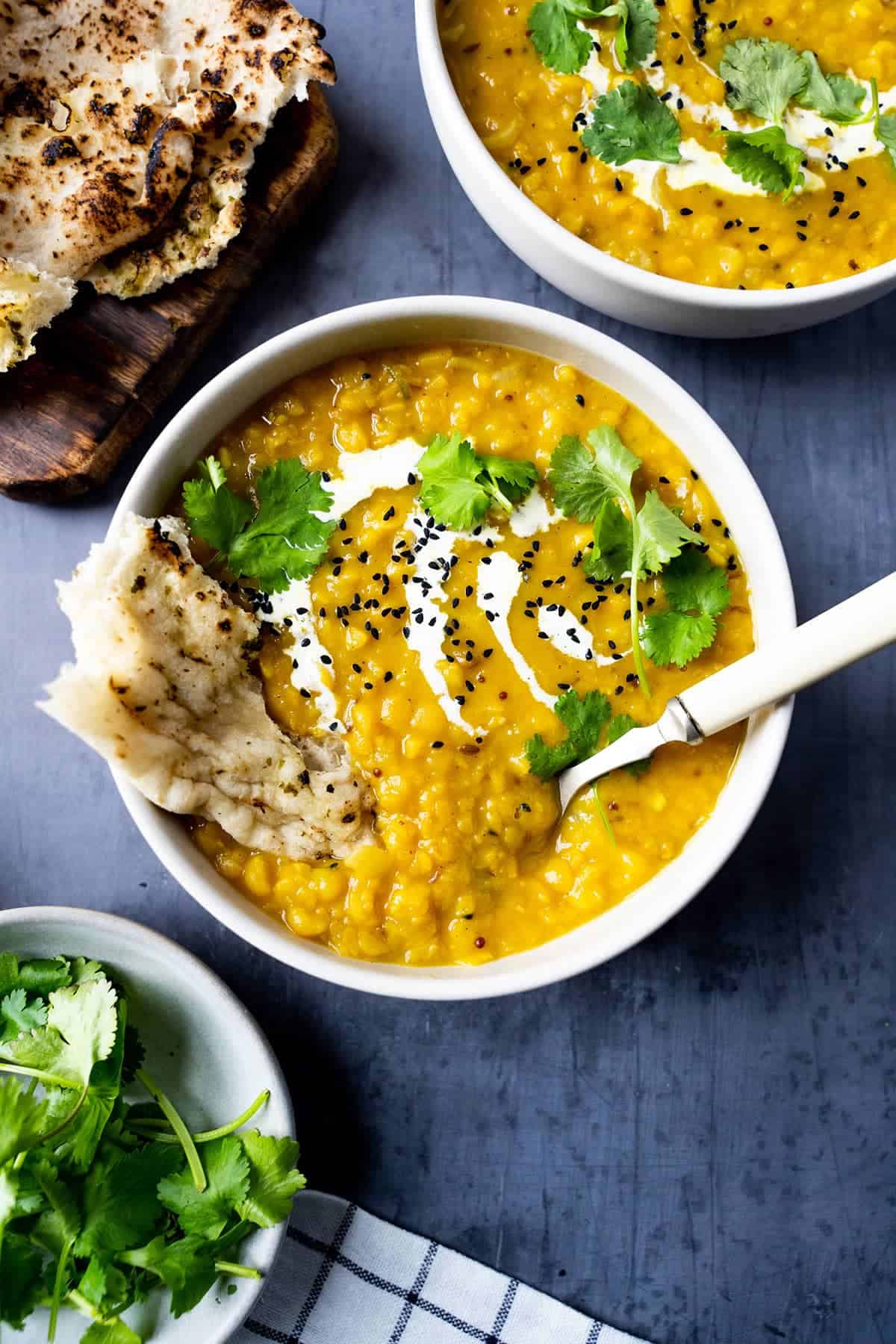 Matar dal in a bowl with naan bread in it.