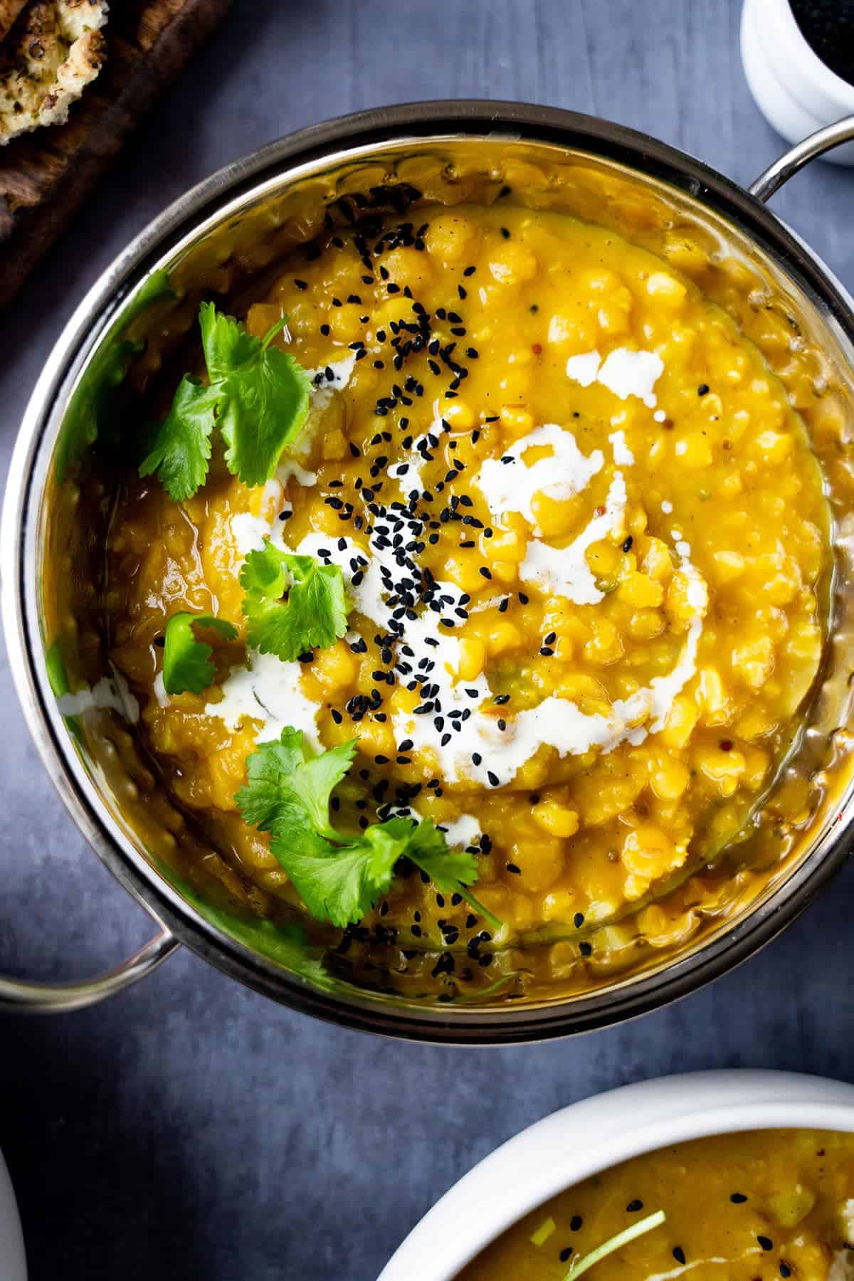 Matar dal in a Balti dish topped with nigella seeds and cream.