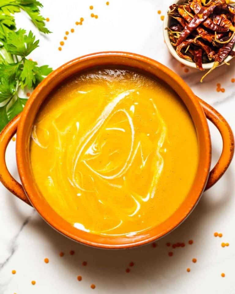 Carrot and lentil soup with in a terracotta bowl with handles.