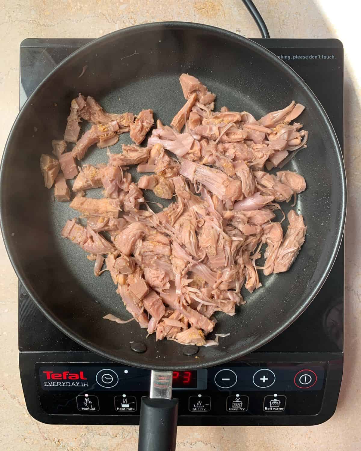 Frying jackfruit in a pan.