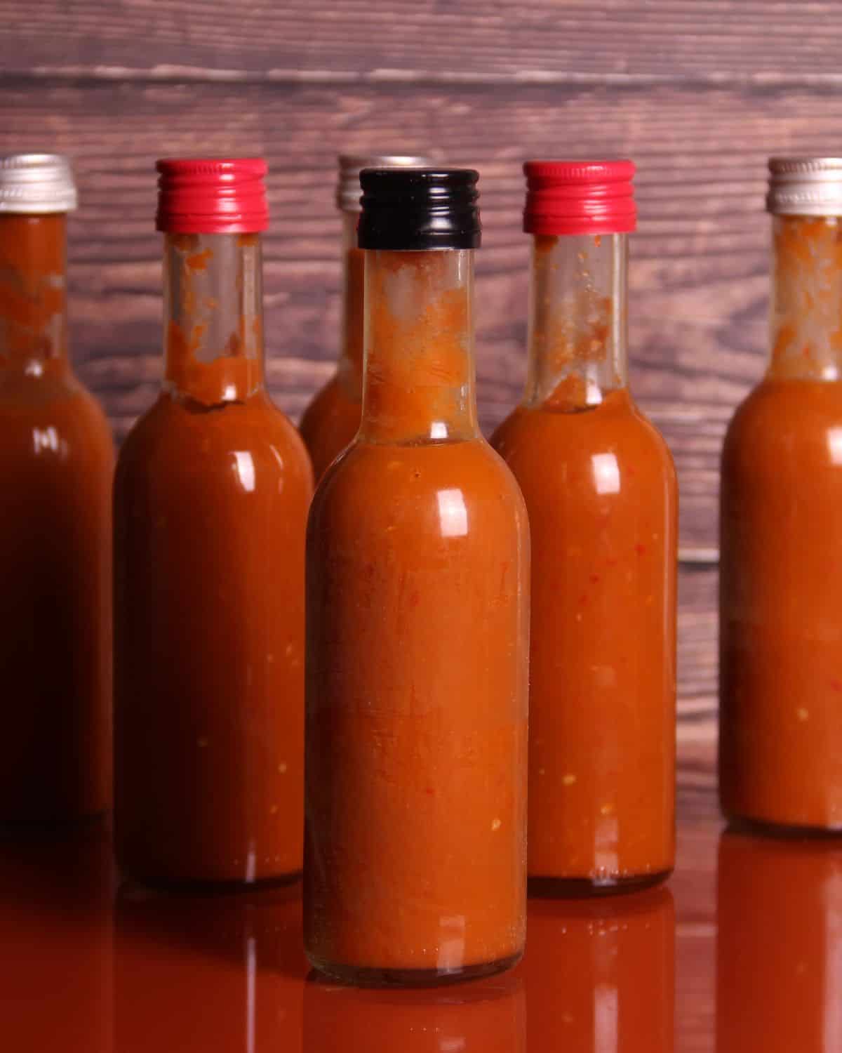 Bottles of hot sauce on a table.