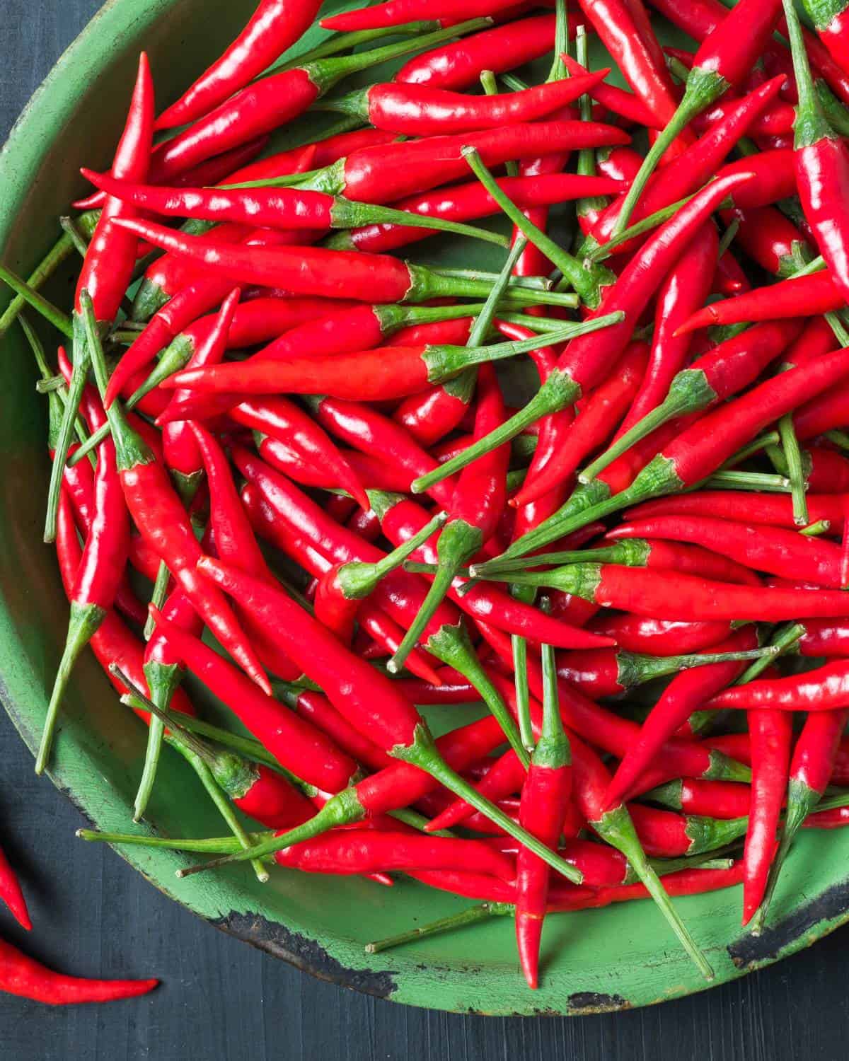 Red bird's eye chili peppers in a bowl.