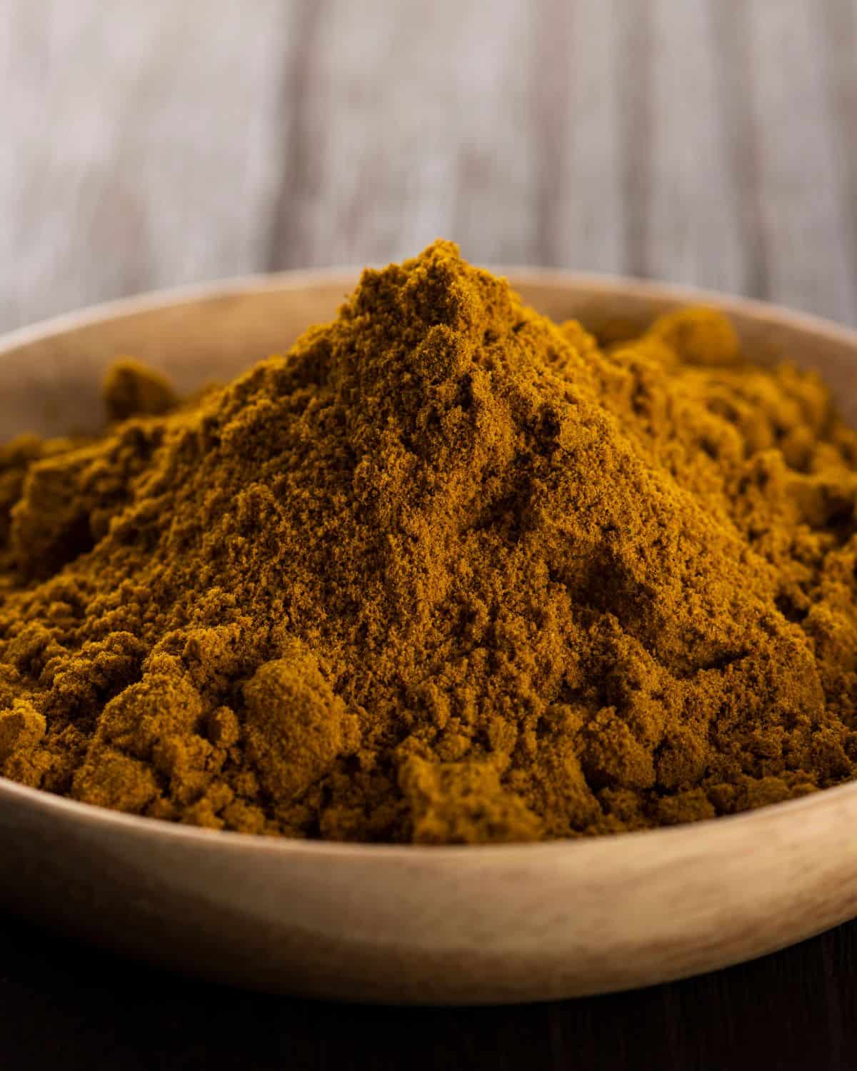 Curry powder in a wooden bowl.