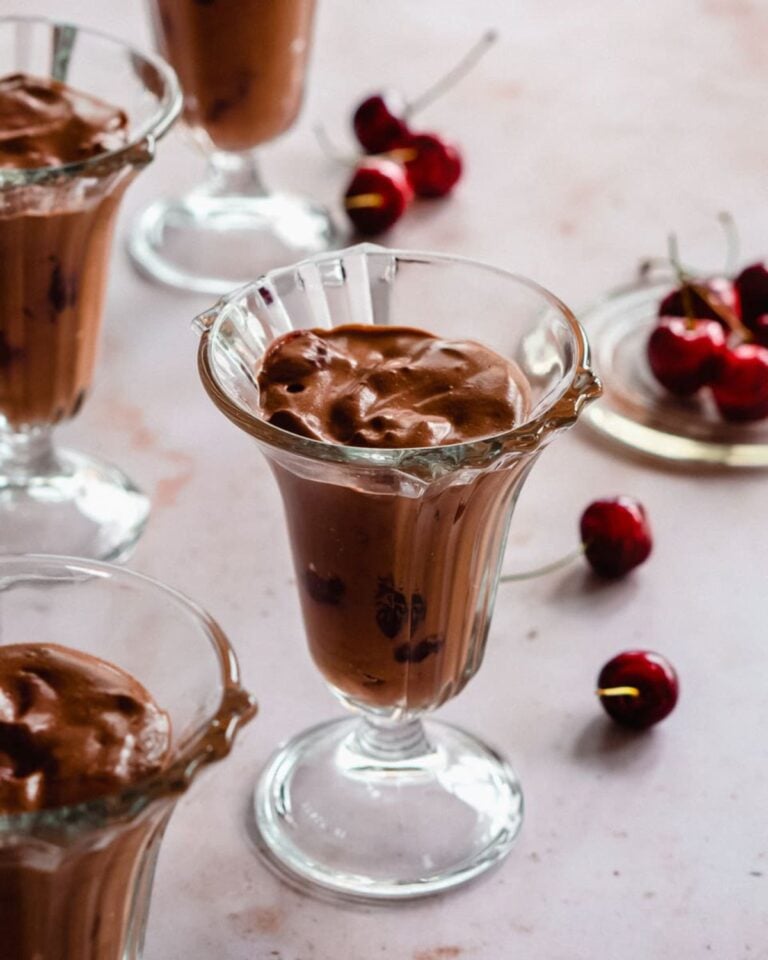 Chocolate mousse in a sundae glass with cherries.