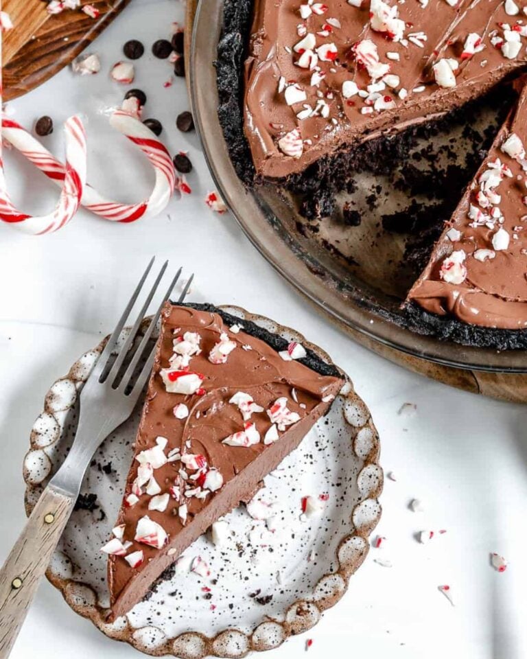 A slice of chocolate peppermint pie with broken up candy canes.