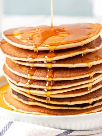 A stack of pancakes with maple syrup.