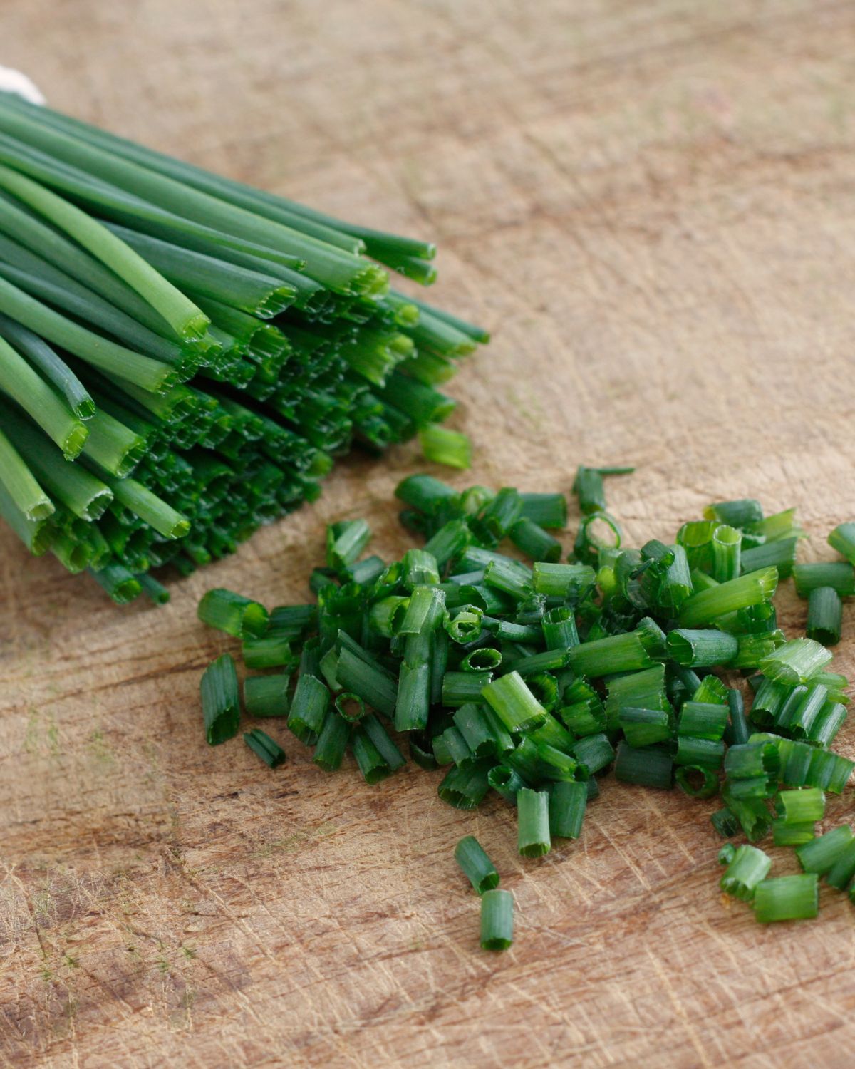 Chopped chives on a cutting board.