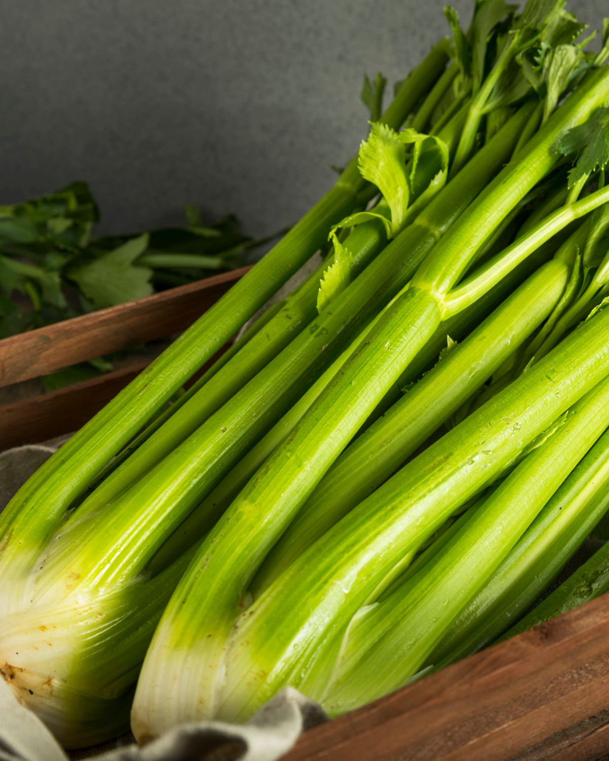 Celery stalks in a wooden crate.