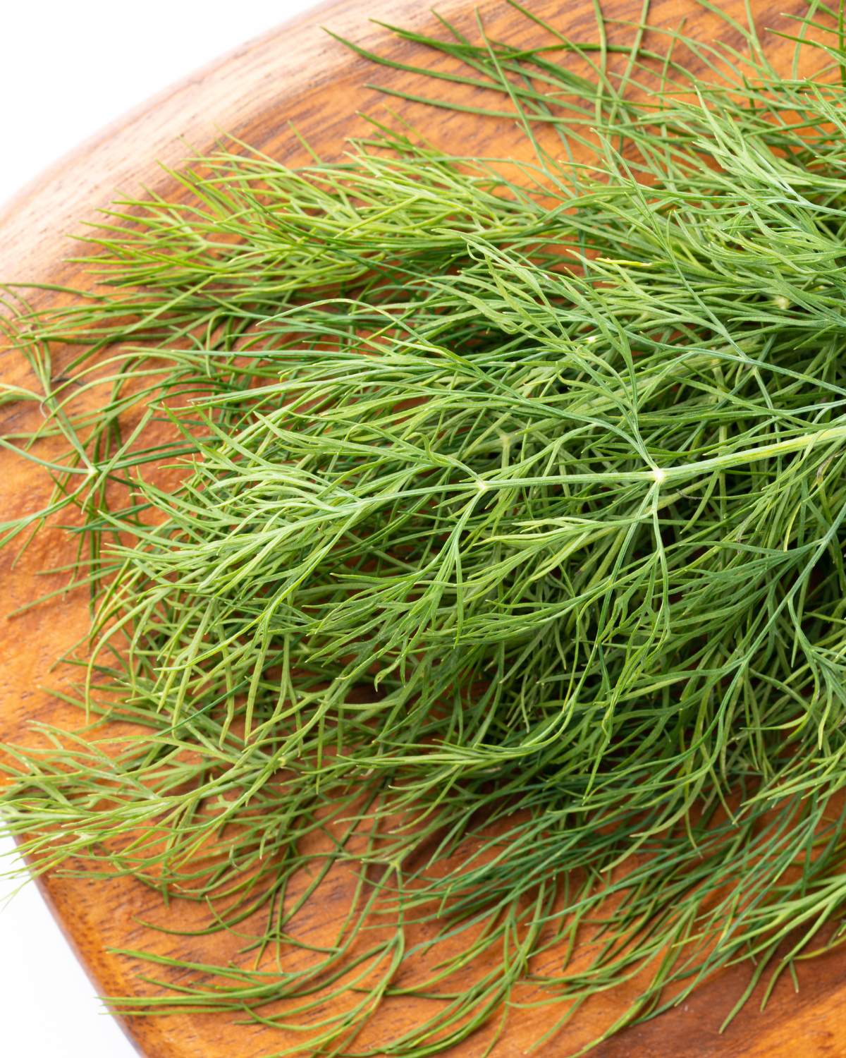 Fresh dill on a wooden chopping board.